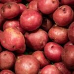 There is a pile of fresh red potatoes.