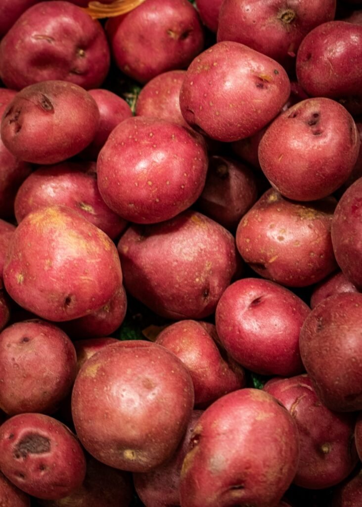 There is a pile of fresh red potatoes.