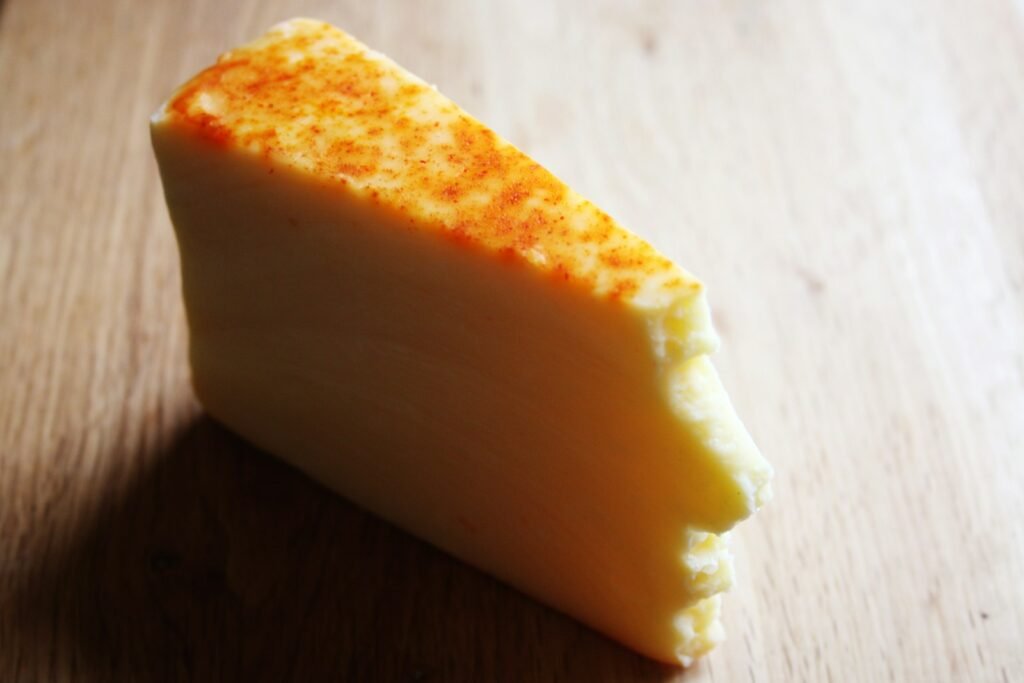 A piece of cheese sitting on top of a wooden table